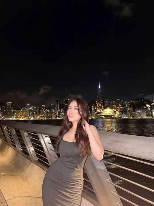 Debbie Sibal in a grey dress by the waterfront at night